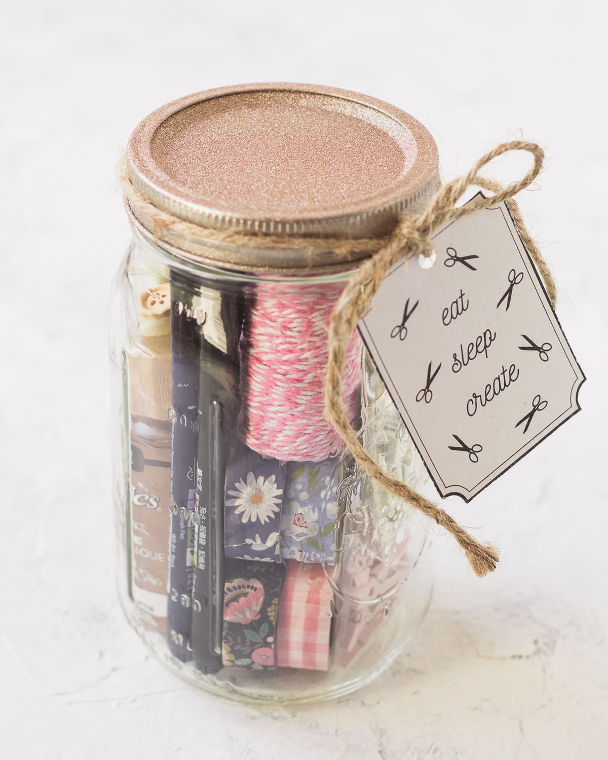 Washi tape and colorful twine in a mason jar with a gift tag.