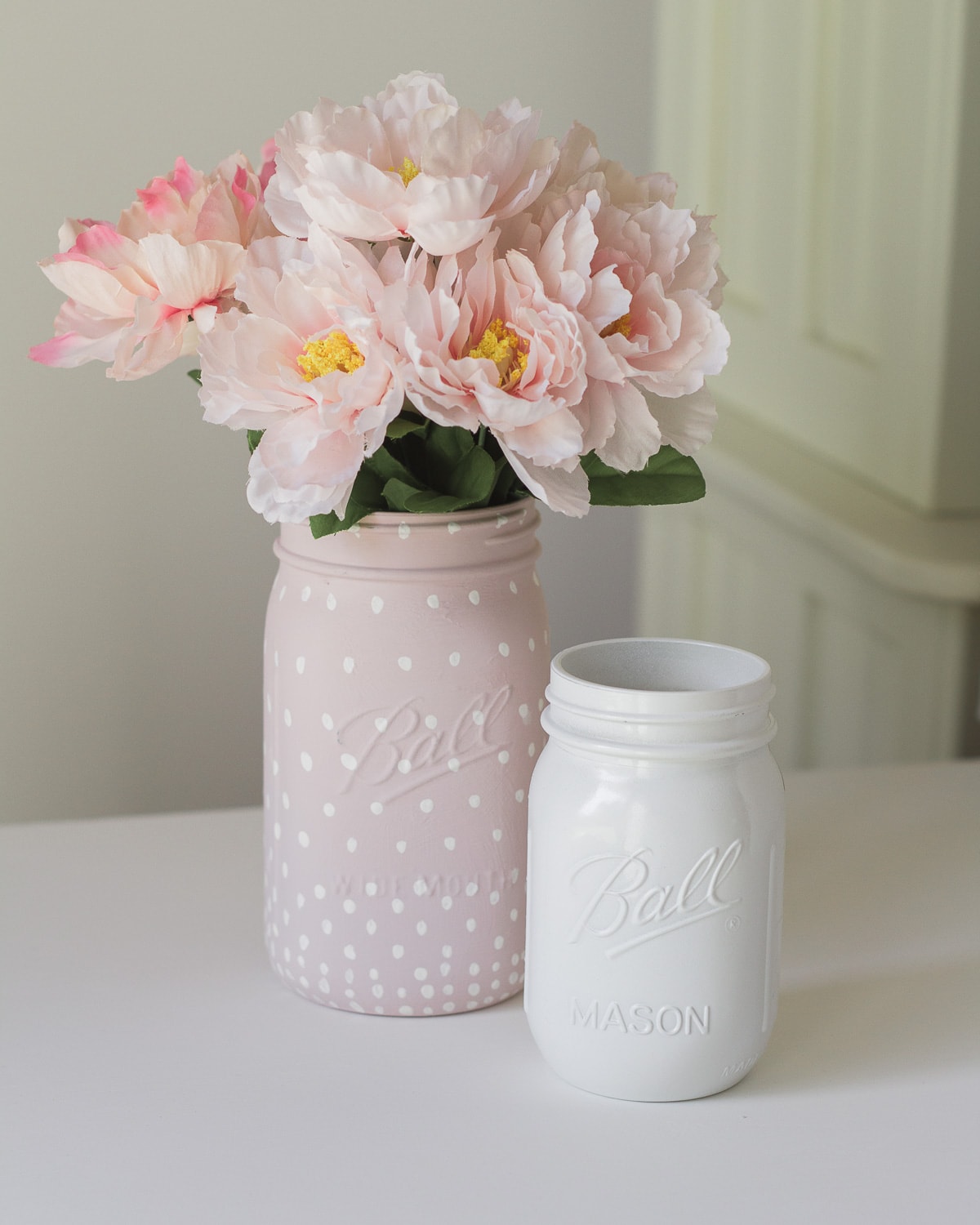 Painted mason jars with flowers inside.