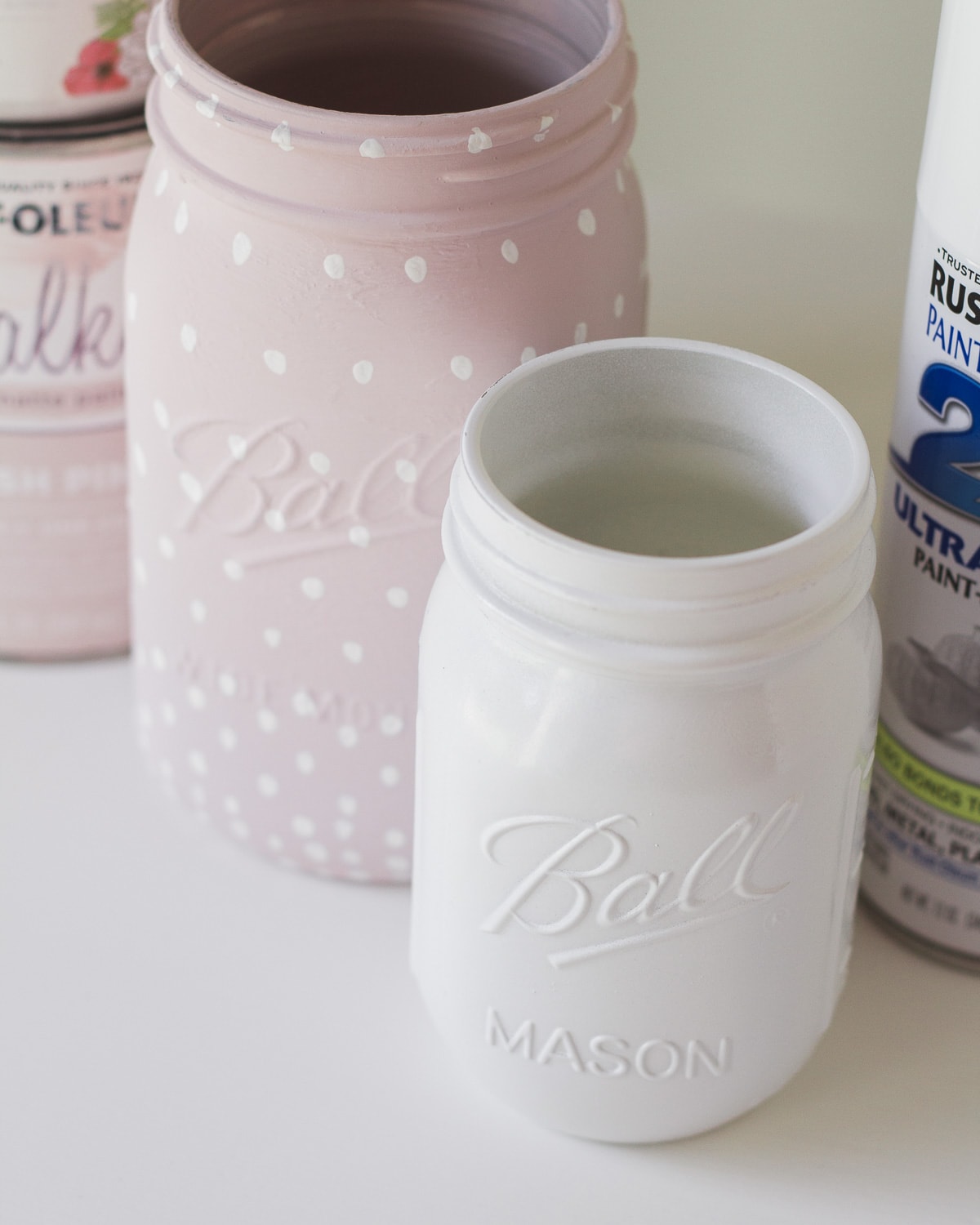 A glass jar painted with glossy white spray paint.