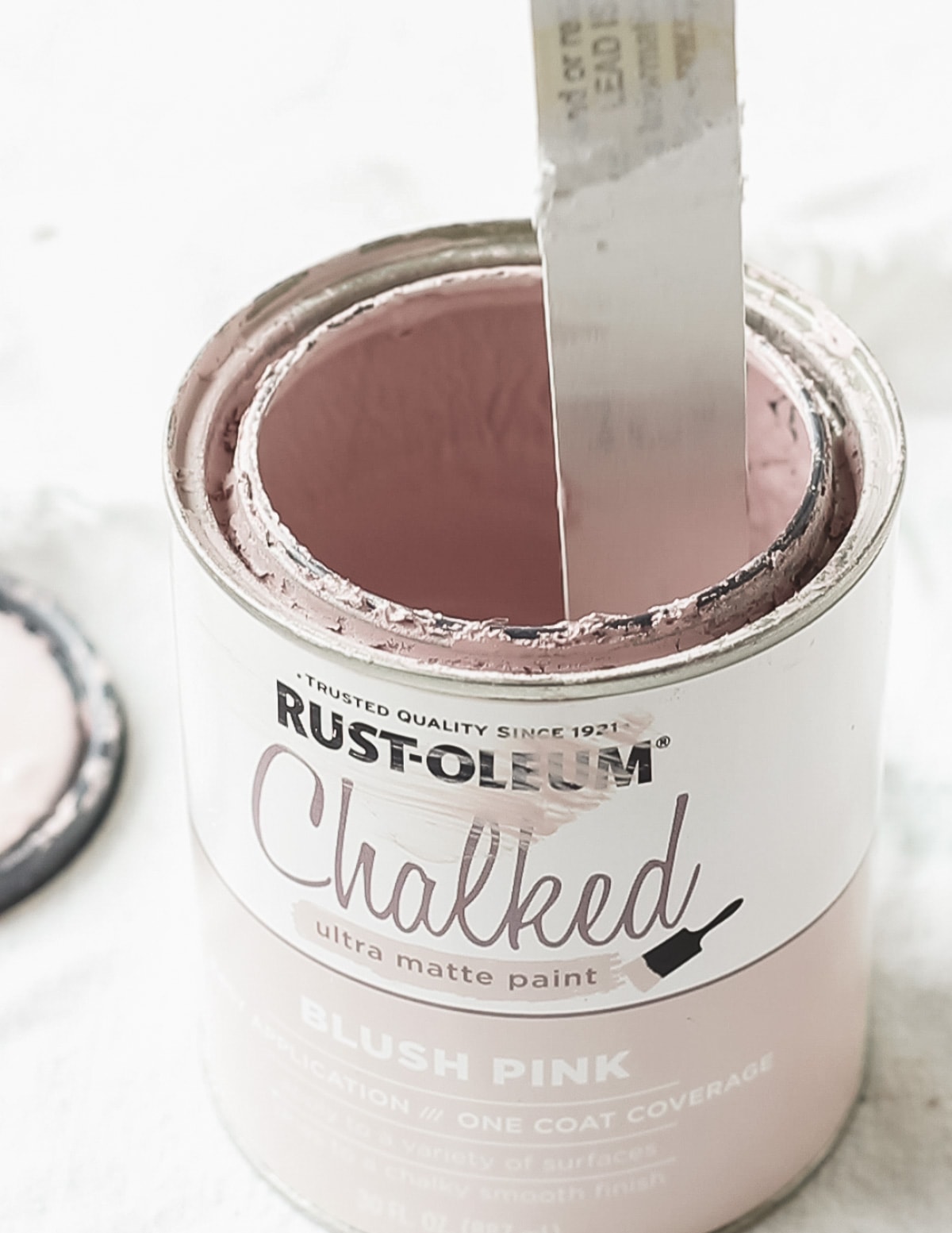 Stirring a can of Rust-Oleum Chalked paint with a stir stick.