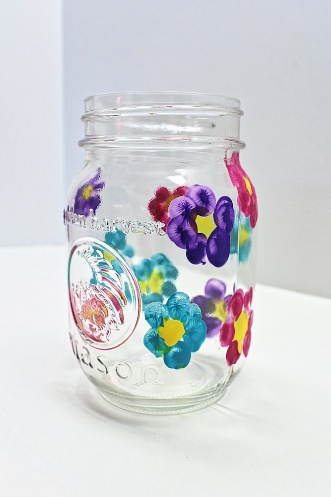 A mason jar with children's thumbprints for Mother's Day.