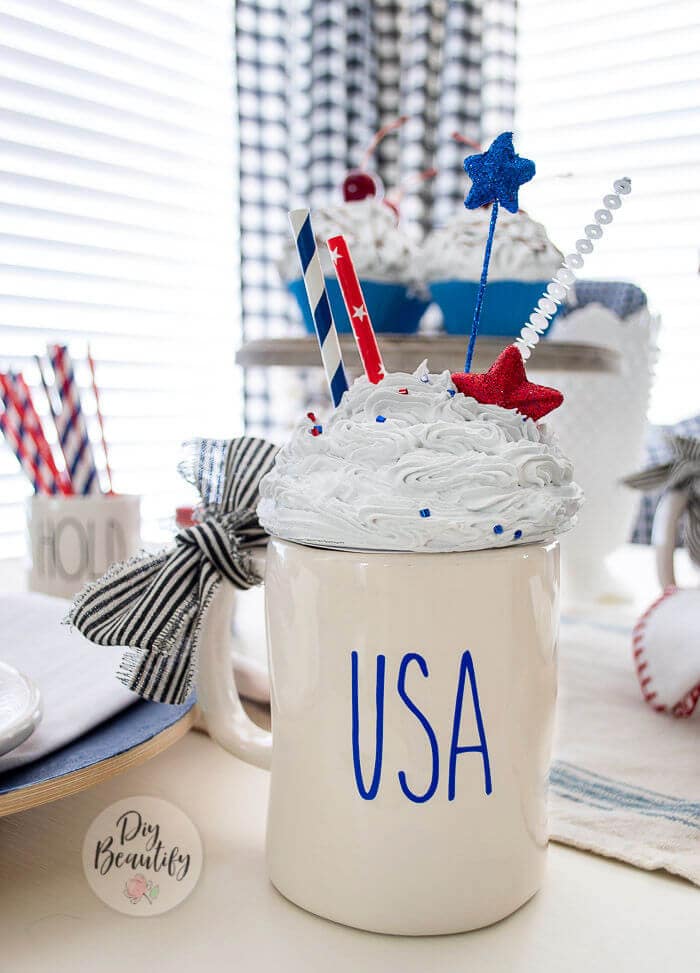 A mug with "USA" on the front and topped with a faux whipped cream topper.