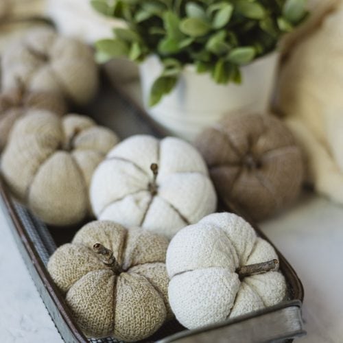 DIY pumpkins made from socks arranged in a metal basket.