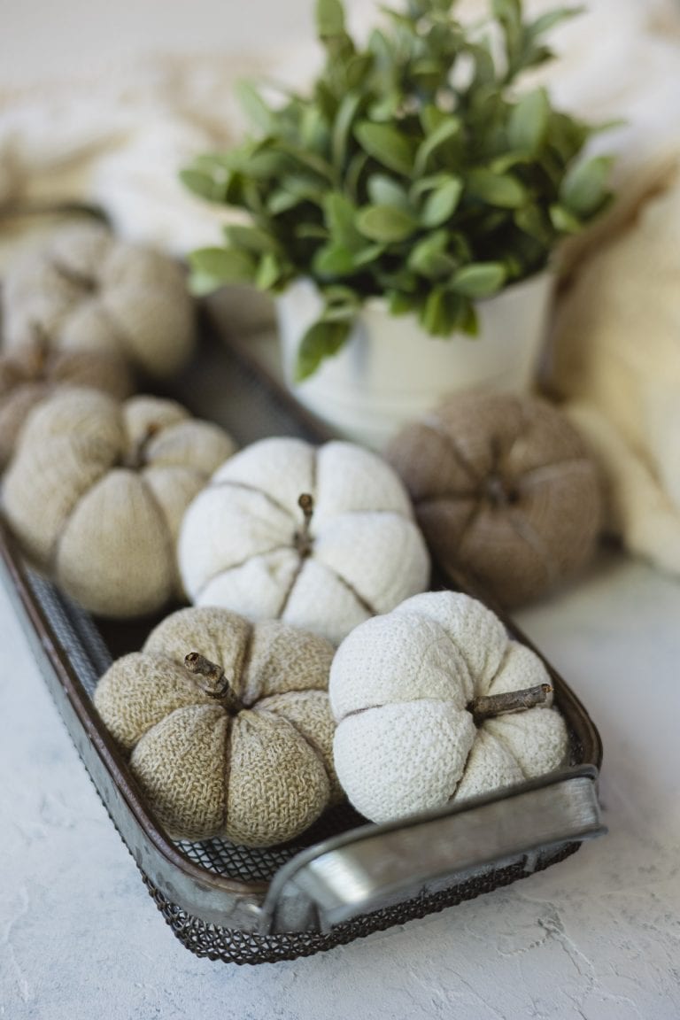 DIY pumpkins made from socks arranged in a metal basket.