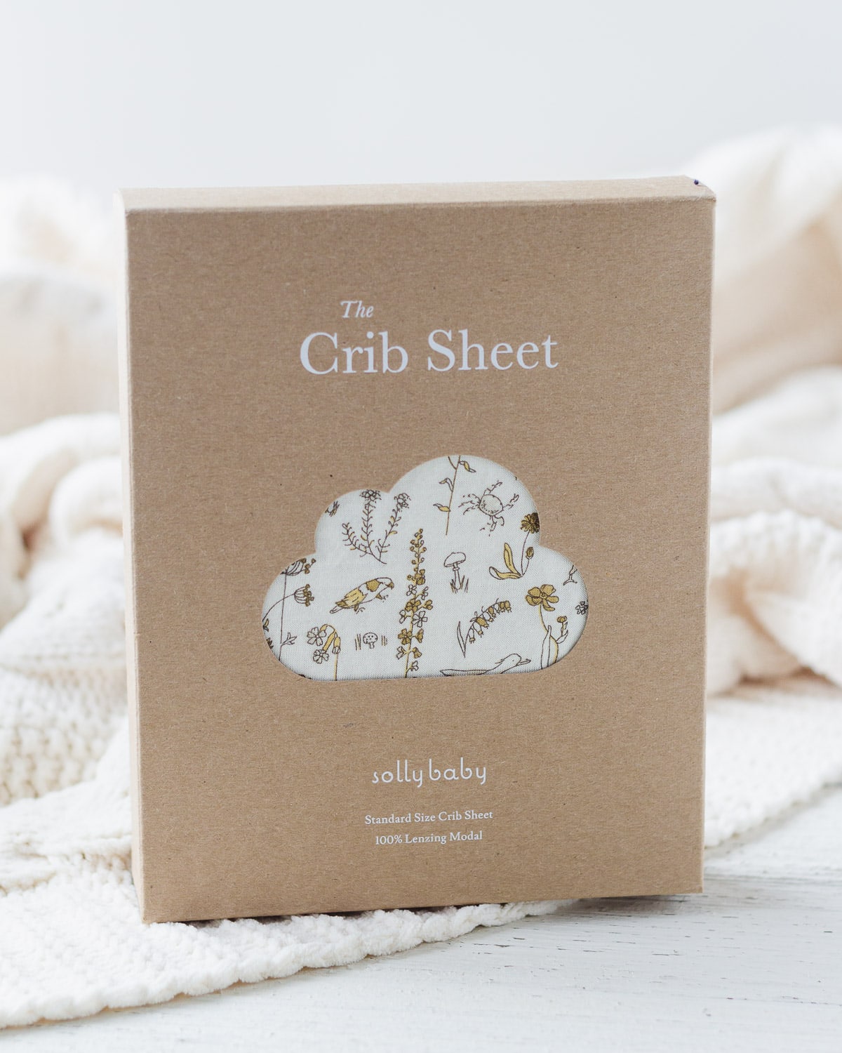 A Solly Baby Crib Sheet inside the original packaging box.