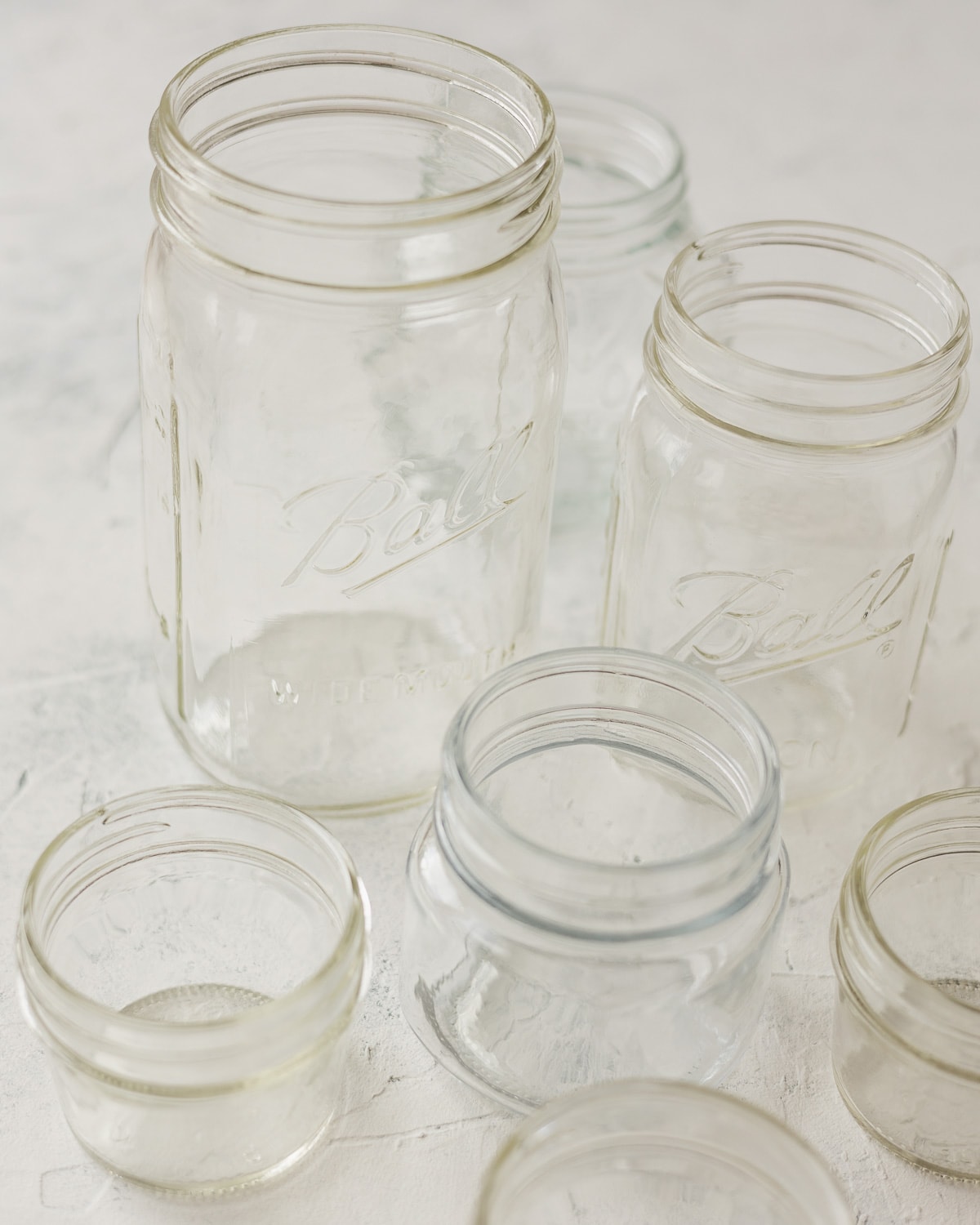 Glass mason jars on a textured surface.