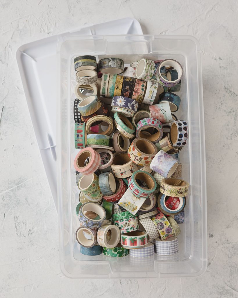 A clear storage box filled with washi tape.