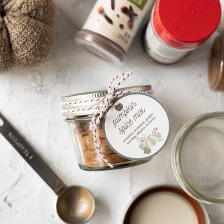 A jar of homemade pumpkin spice mix tied with a printable gift tag.