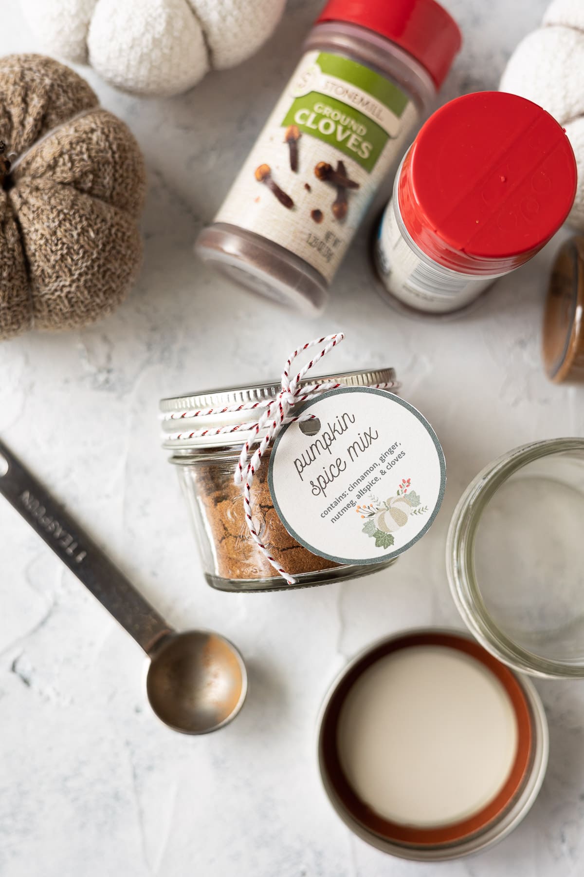 A jar of homemade pumpkin spice mix tied with a printable gift tag.