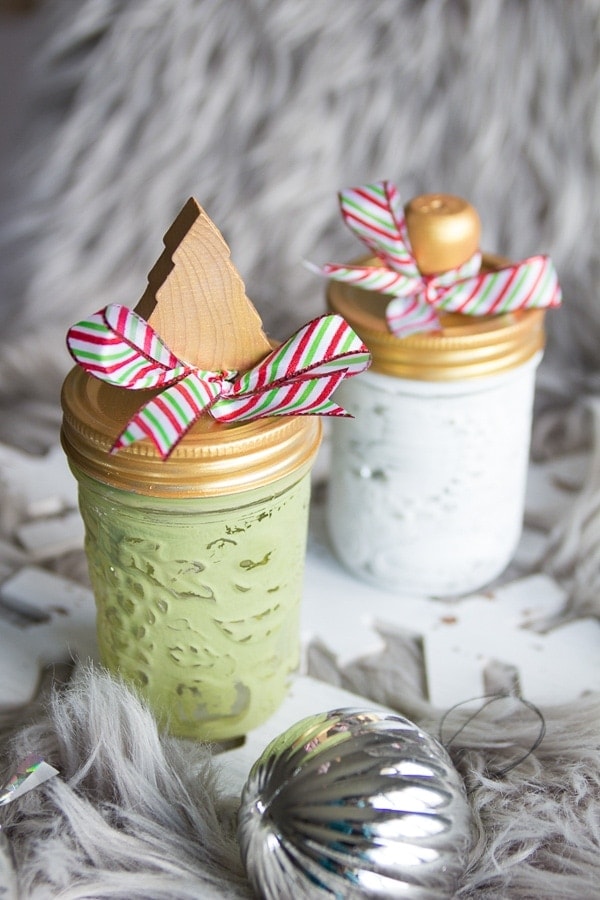 Painted mason jars with Christmas embellishments on the lids.