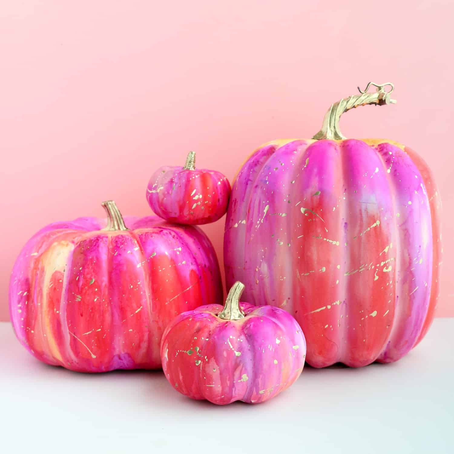 Bright pink and purple alcohol ink pumpkins with gold spatters.