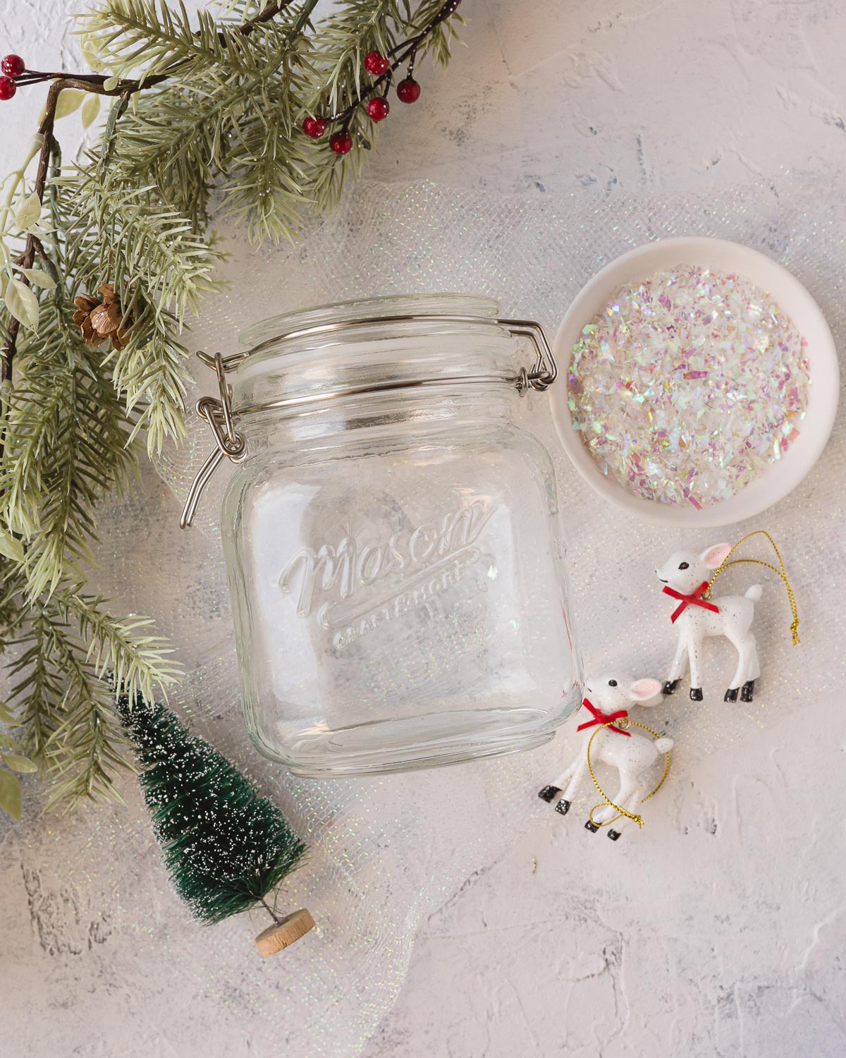 Faux snow, a mason jar, bottle brush tree, and mini deer ornaments.