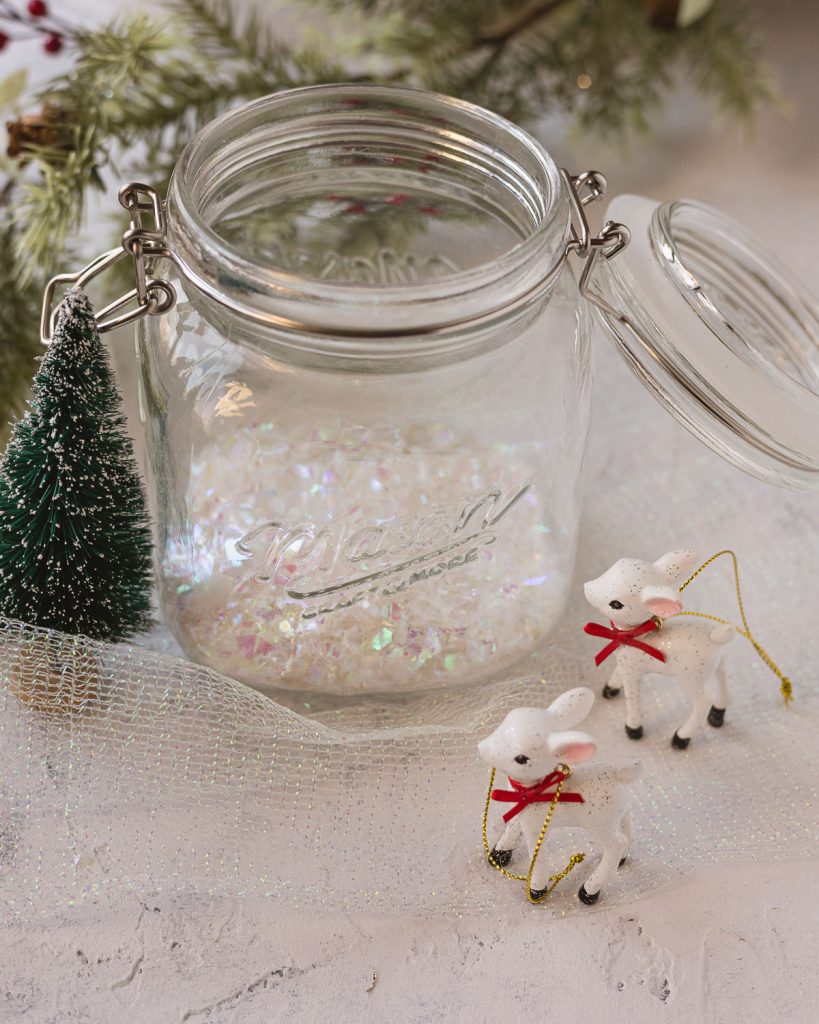 Mini white reindeer ornaments and a mason jar filled with faux snow.