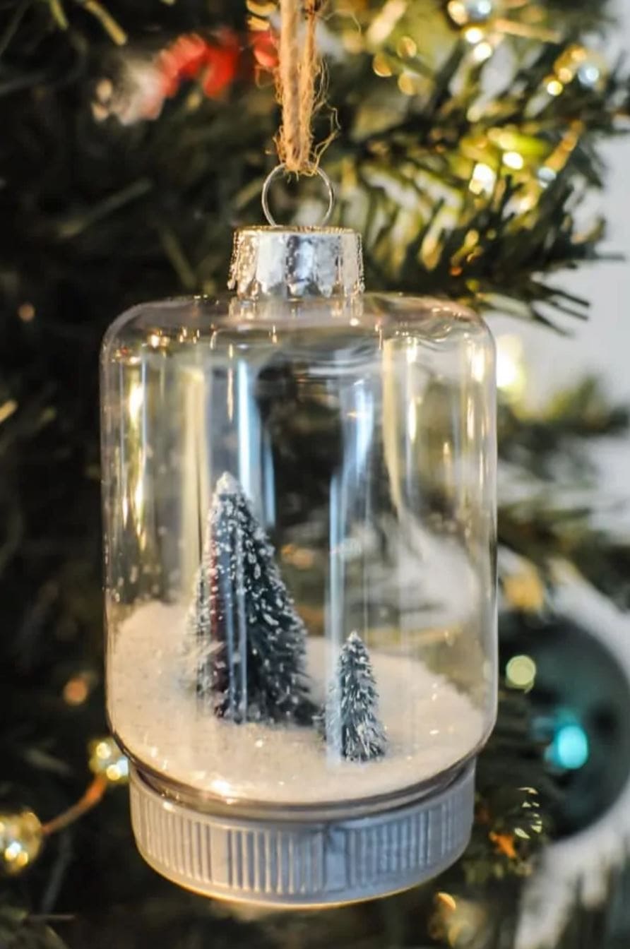 A mason jar snow globe with bottle brush trees.