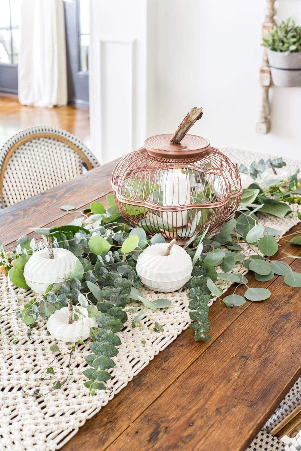 A fall tablescape with pumpkins made from Bundt pans and a wire basket.