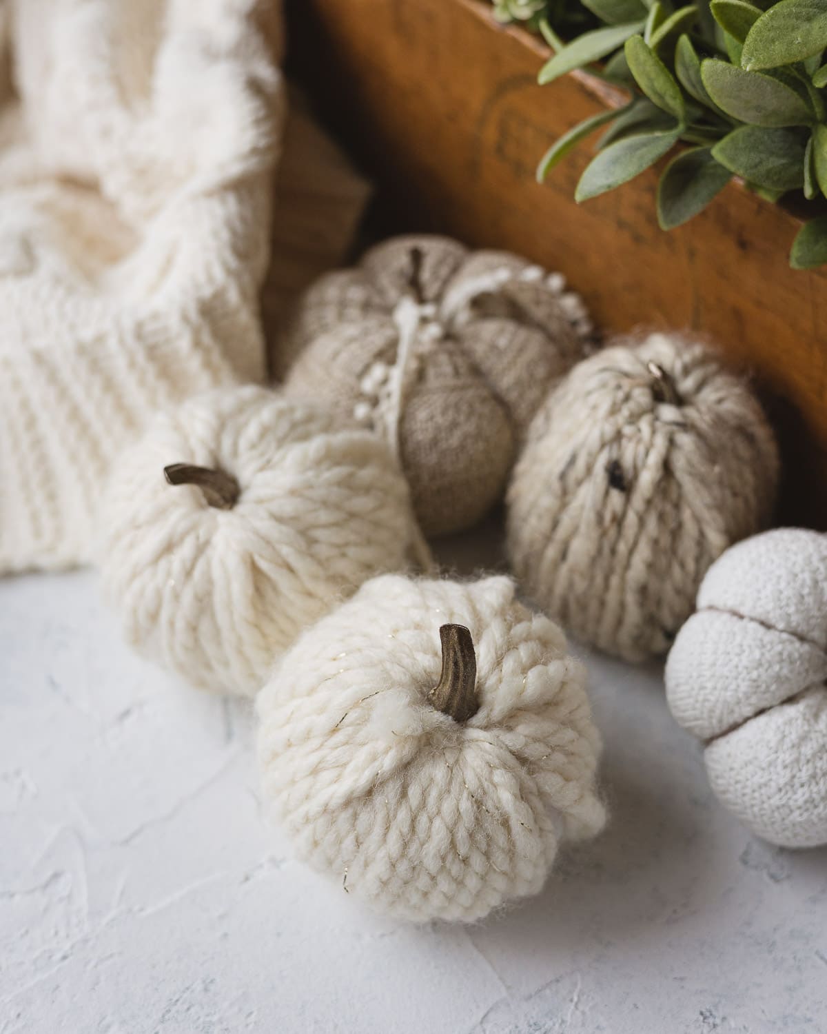 Yarn pumpkins with faux pumpkin stems.