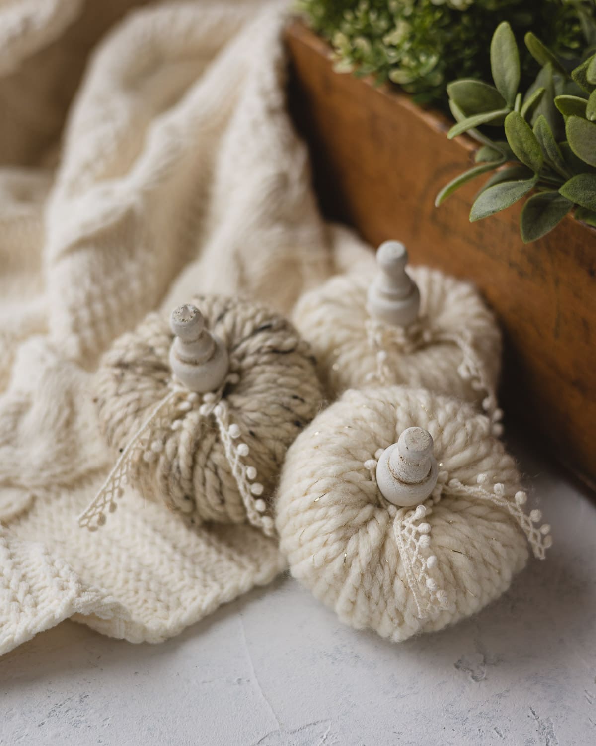 Yarn wrapped pumpkins with wooden stems and lace detail.