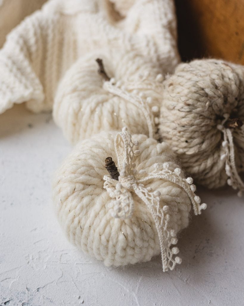 Yarn wrapped pumpkins with twig stems and lace detail.