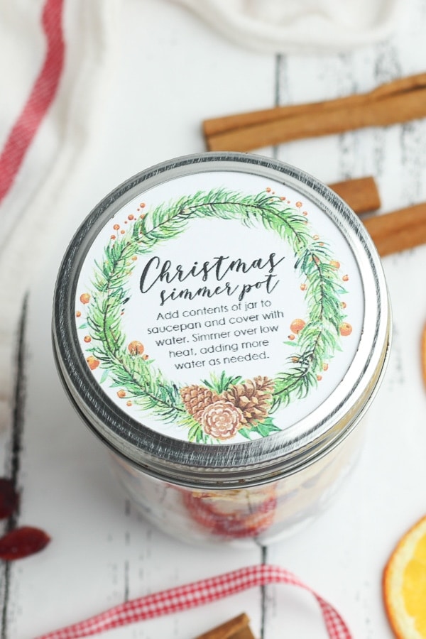 A Christmas Simmer Pot jar with a custom circular label.