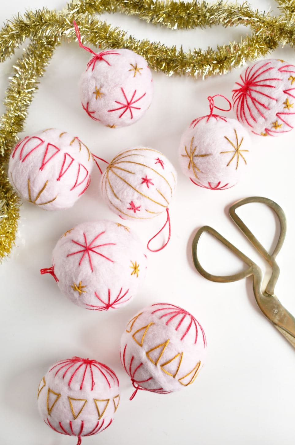 Embroidered wool ornaments with red and gold stitching.