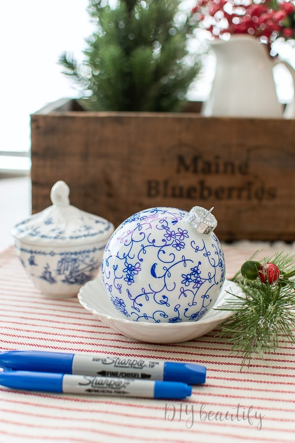 White ceramic ornaments with blue floral designs made with a fine Sharpie pen.