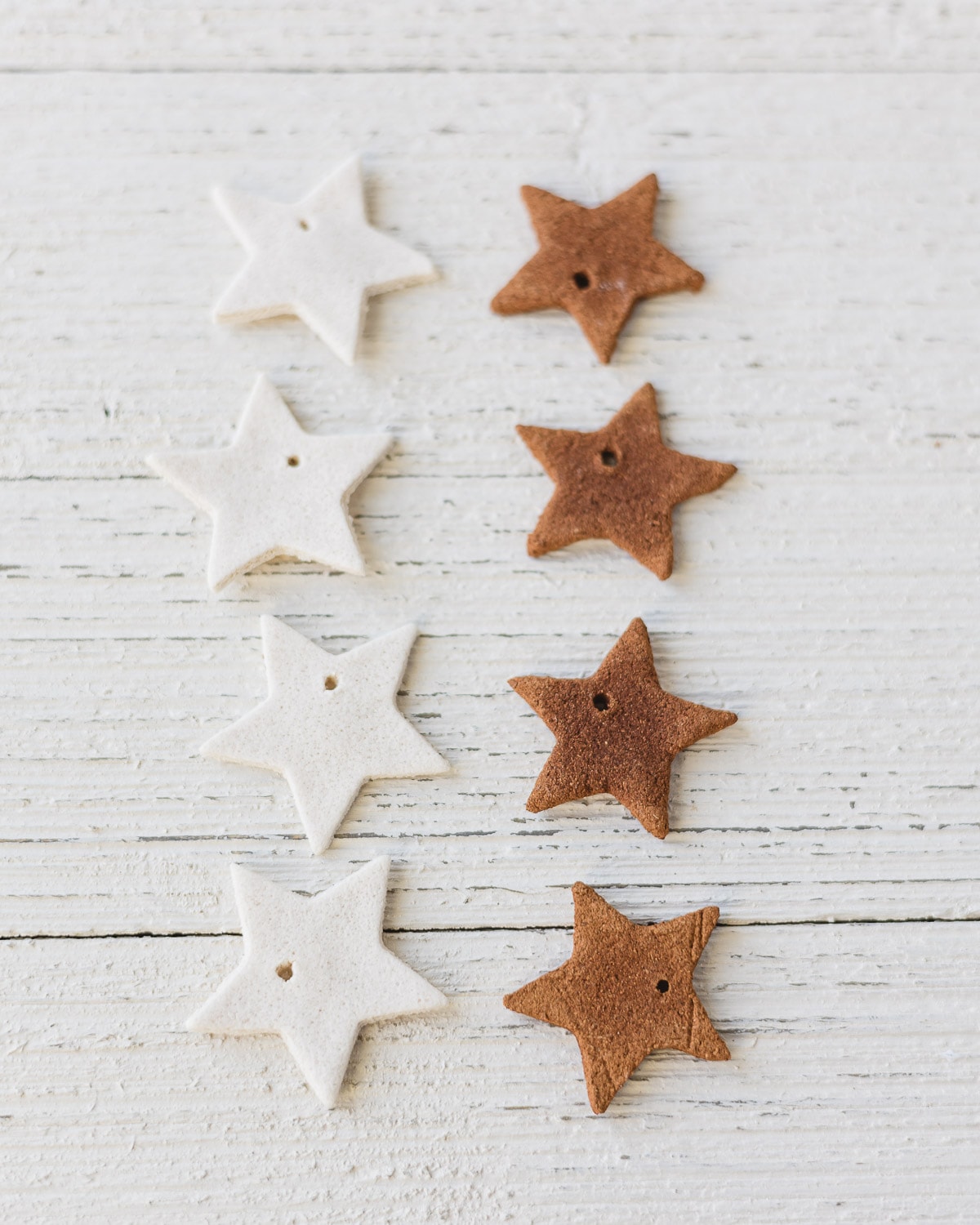 Salt dough star cutouts and cinnamon-applesauce star cutouts on a wooden surface.