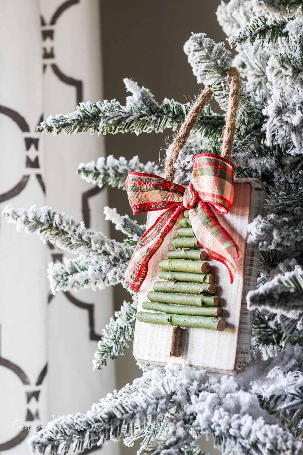 A green Christmas tree ornament made with twigs.