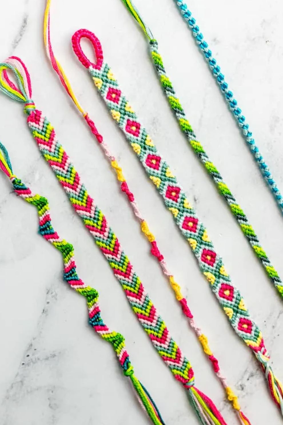 A row of colorful friendship bracelets in various patterns.