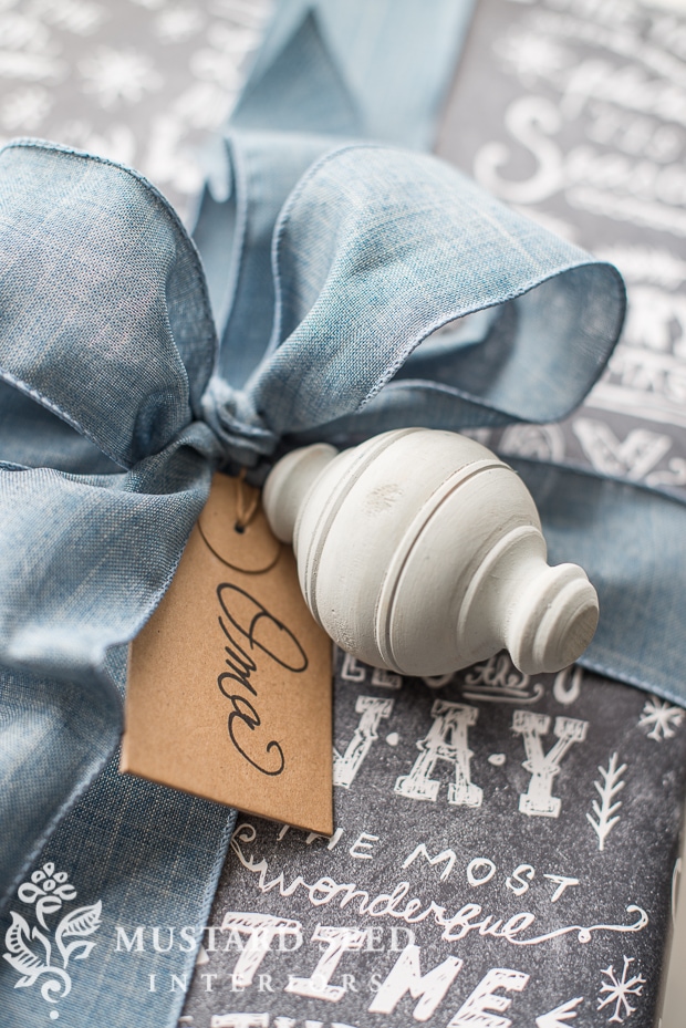 Wooden ornament painted with milk paint and tied with a large blue bow.