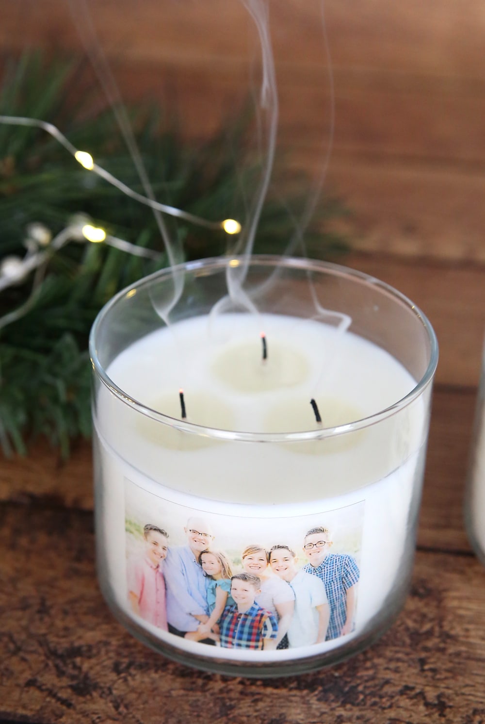 A white candle with a family photo on it.