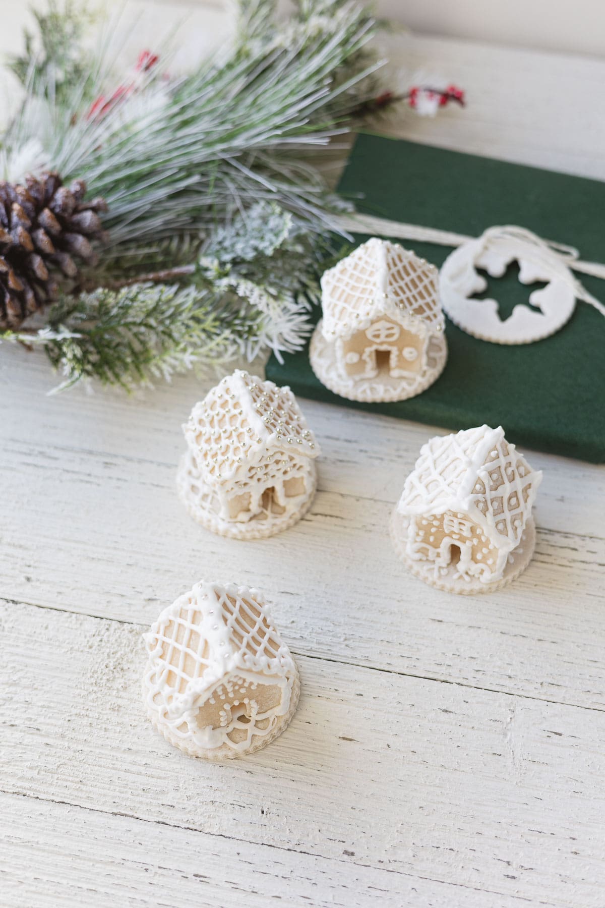 Four miniature white gingerbread houses.