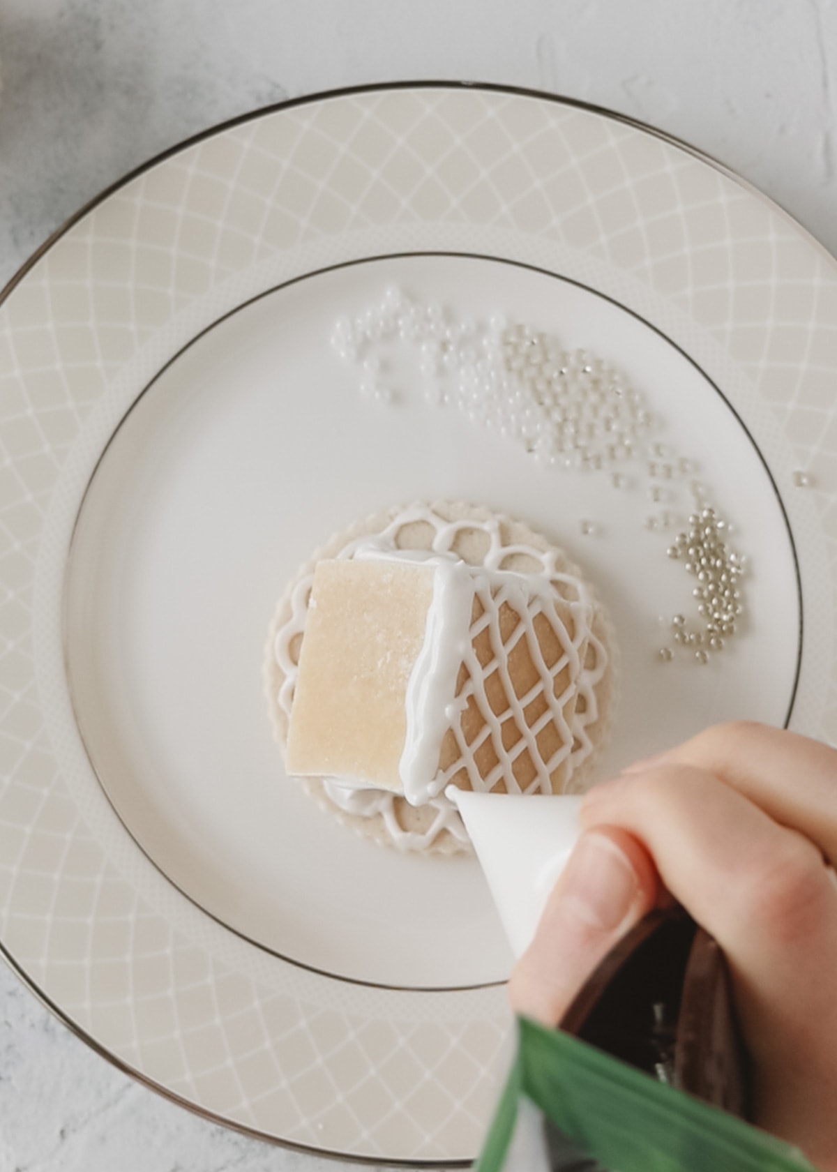 Piping details onto the roof of a mini gingerbread house.