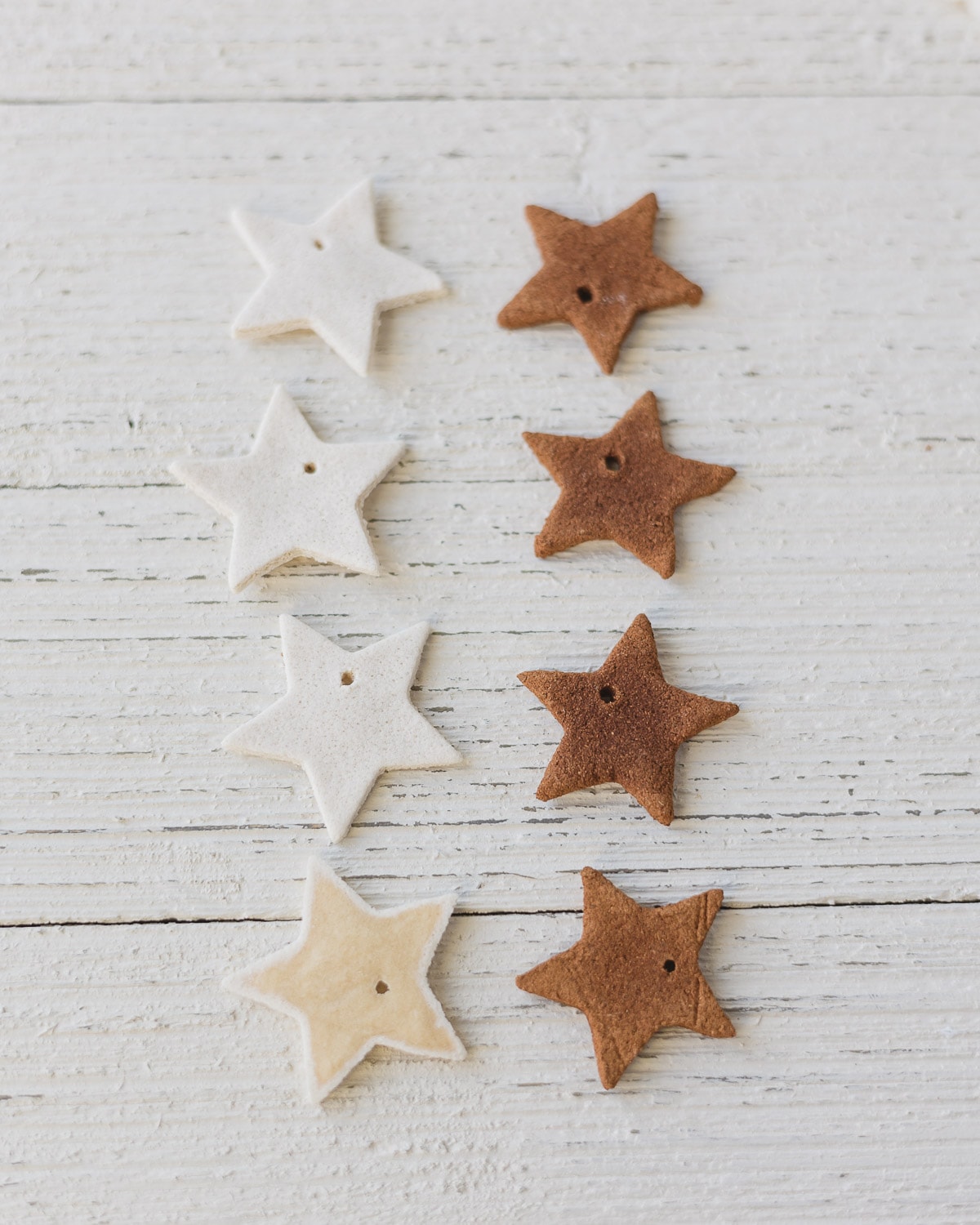 Salt dough stars and cinnamon applesauce stars on a wooden surface.