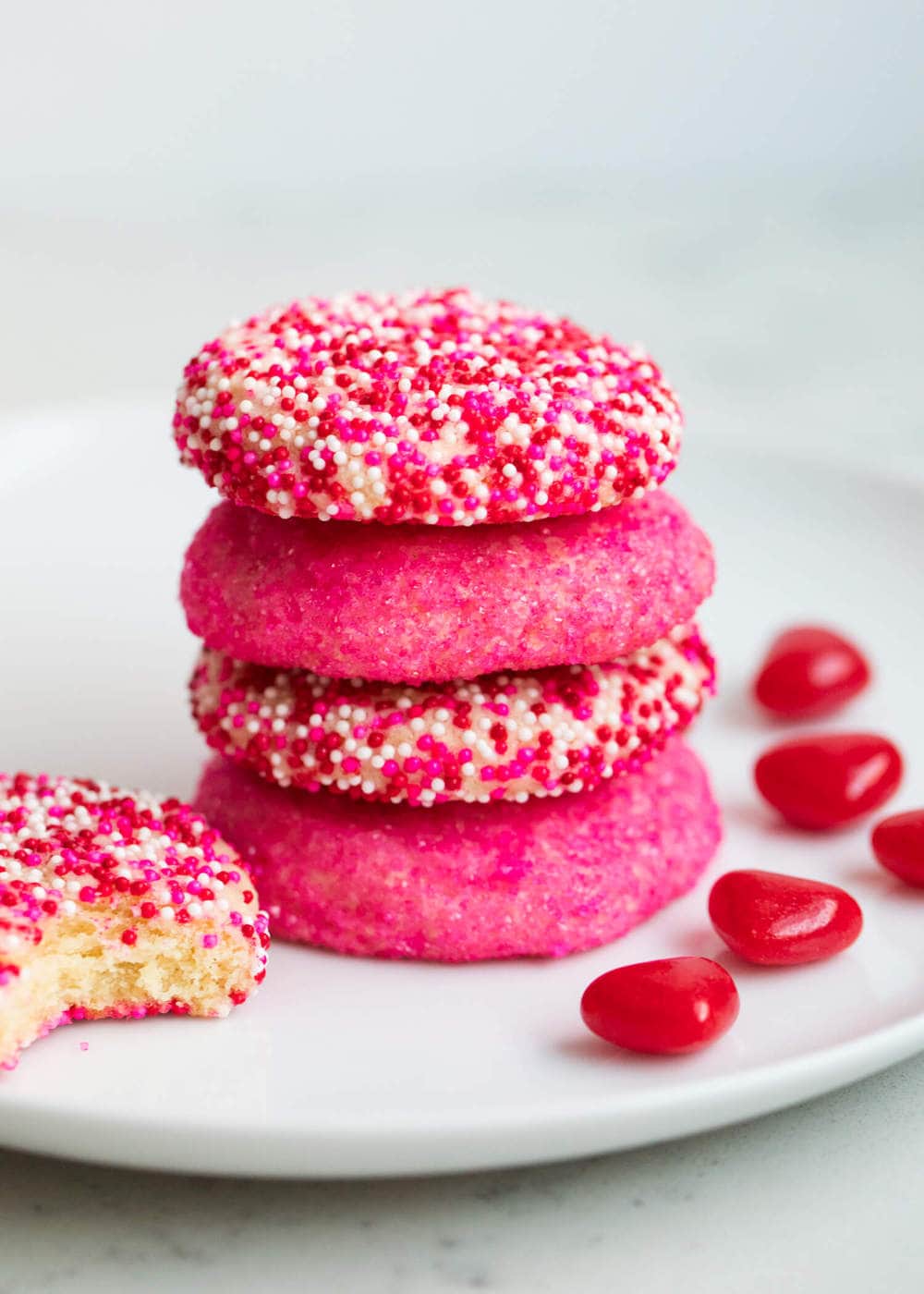 A stack of pink sugar cookies decorated with sprinkles.