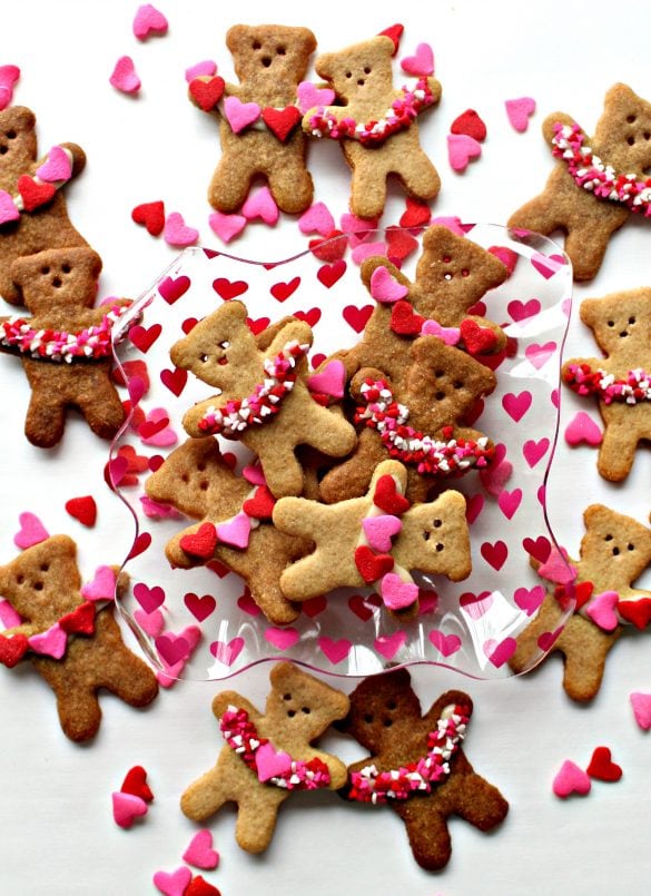 Bear cookies decorated with garlands of pink hearts in their arms.