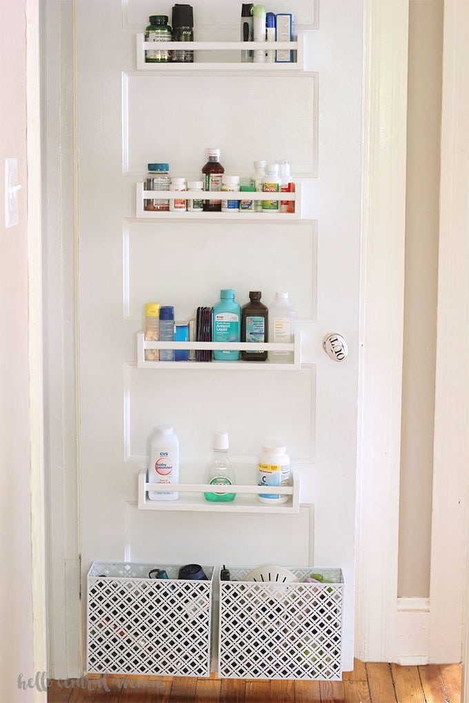 Storage on the back of a linen closet door with IKEA spice racks.