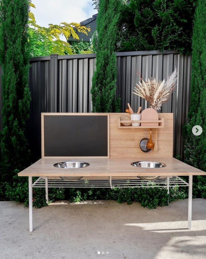 A play outdoor mud kitchen with basins and organization.