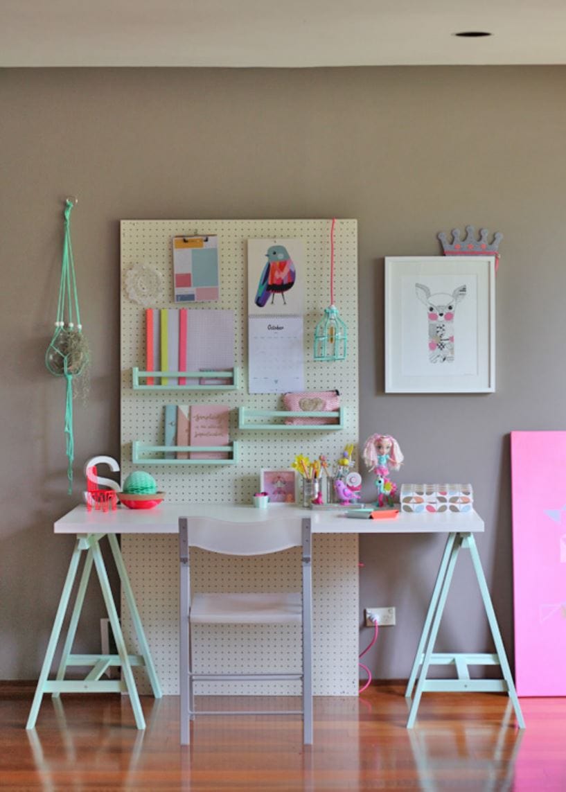 A desk and pegboard workspace with IKEA bekvam spic racks organizing supplies.