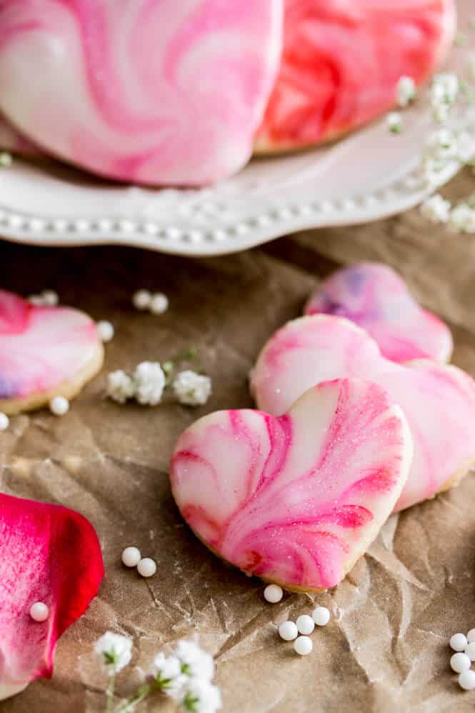 Sugar cookies with marbled pink frosting.