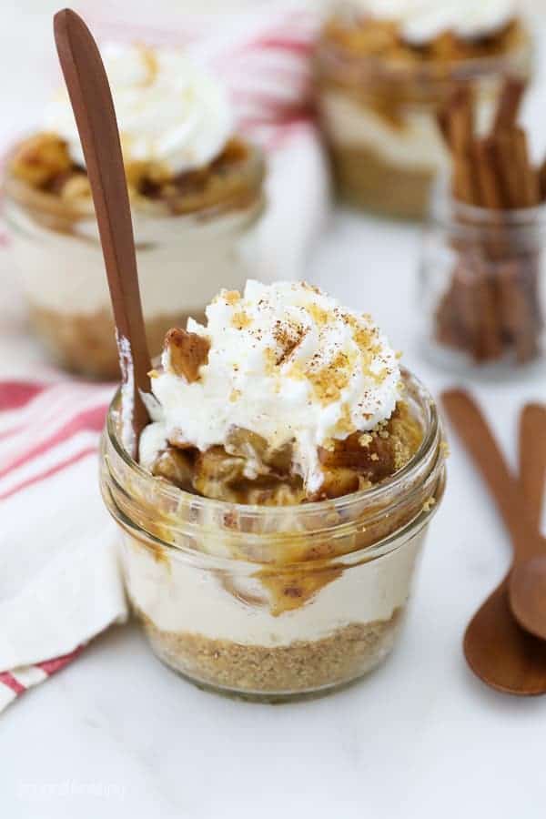 Mini mason jar filled with apple cheesecake and a small spoon.