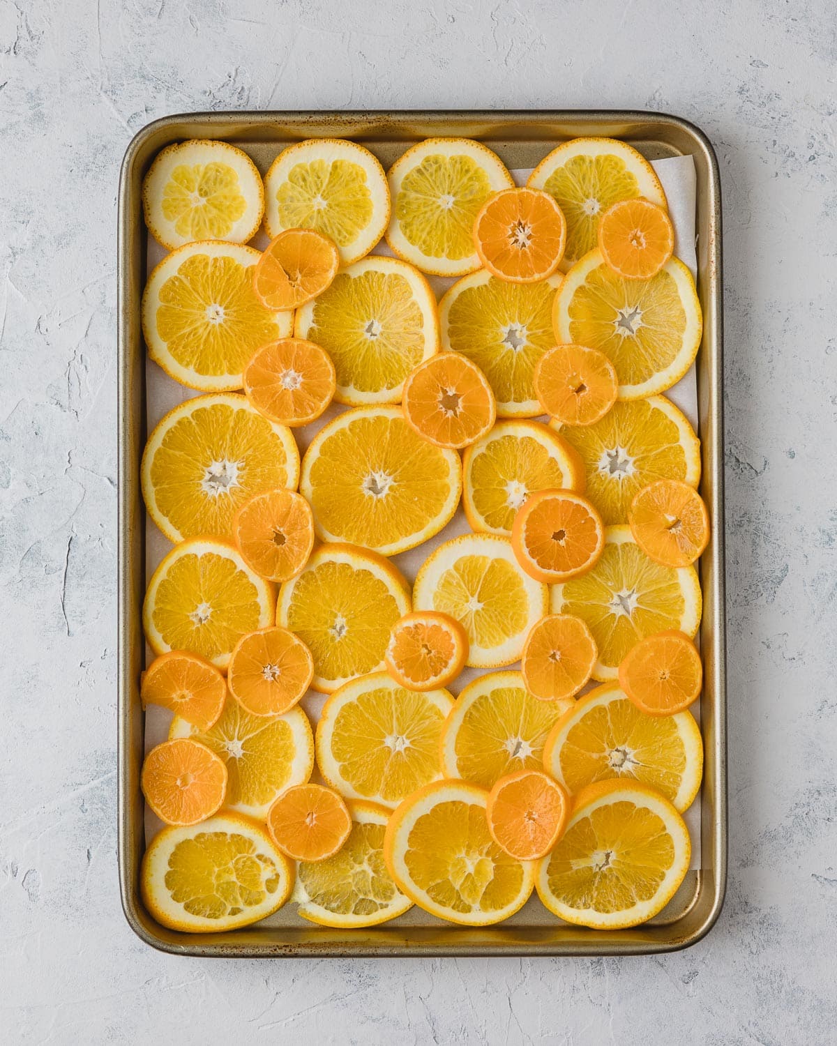 A baking tray filled with sliced oranges and clementines.