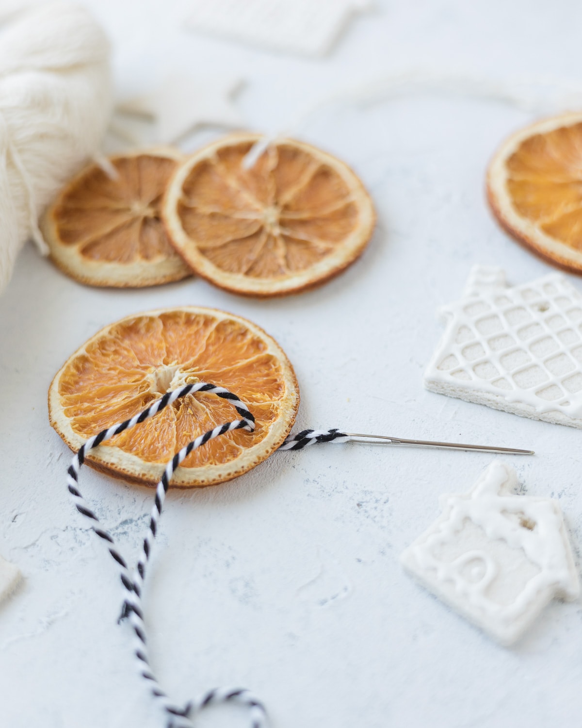 Sewing a string hanger through an orange slice ornament.