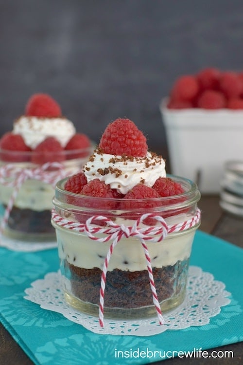 A layered raspberry and brownie dessert in a jar.