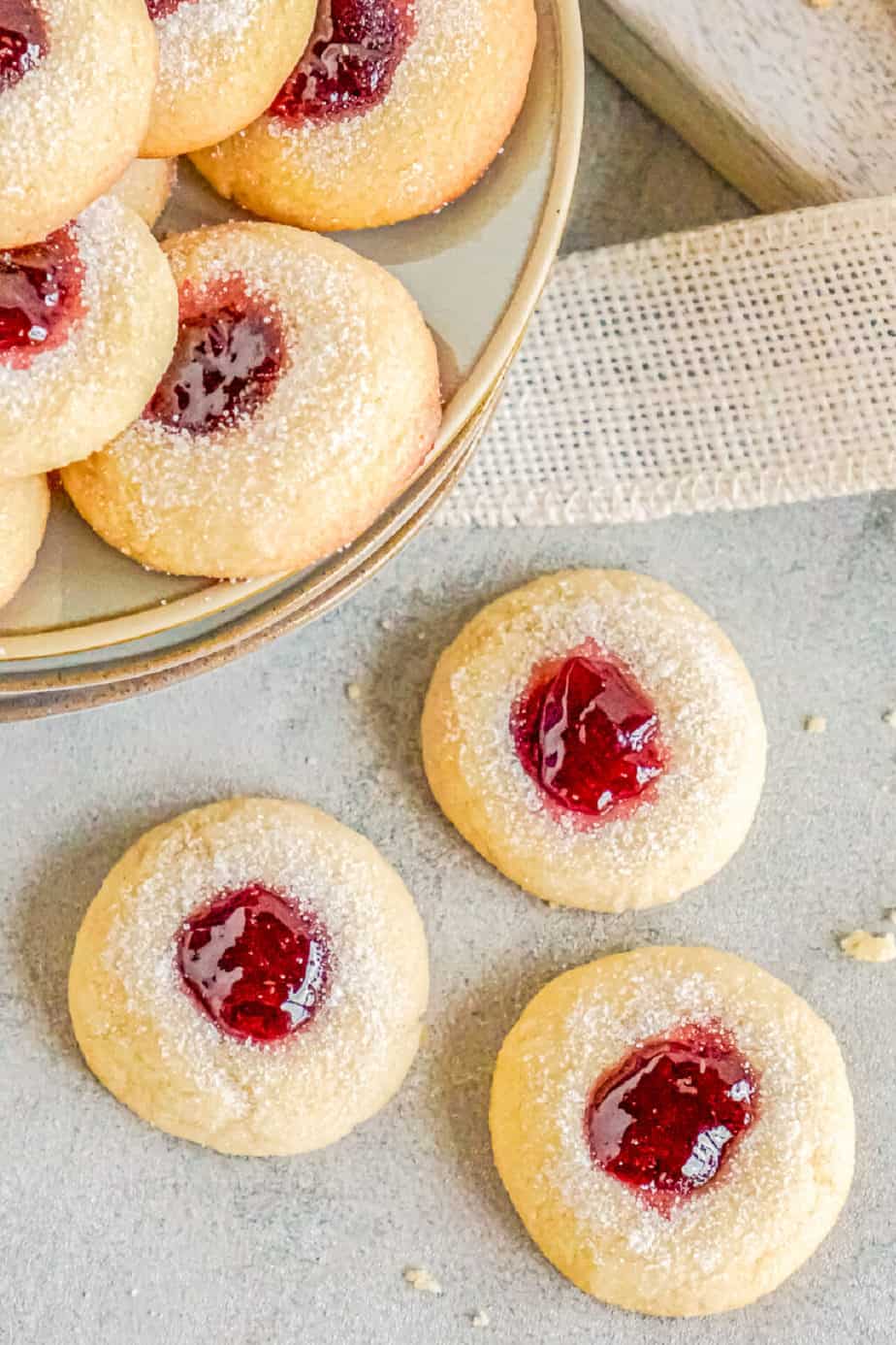 Raspberry Thumbprint cookies on a rustic surface.