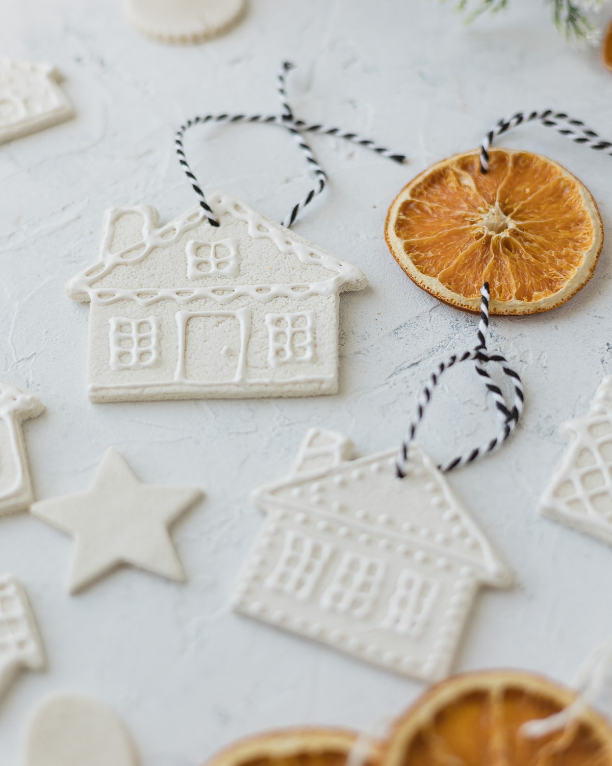 Homemade salt dough ornaments with white and black string for hangers.