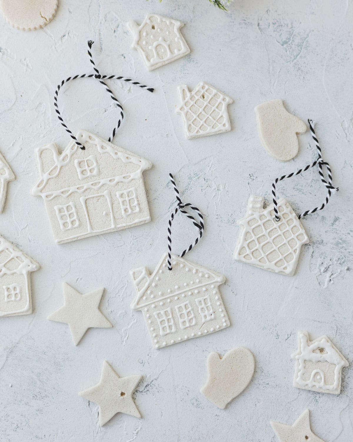 A selection of salt dough ornaments, some decorated with white puffy paint.