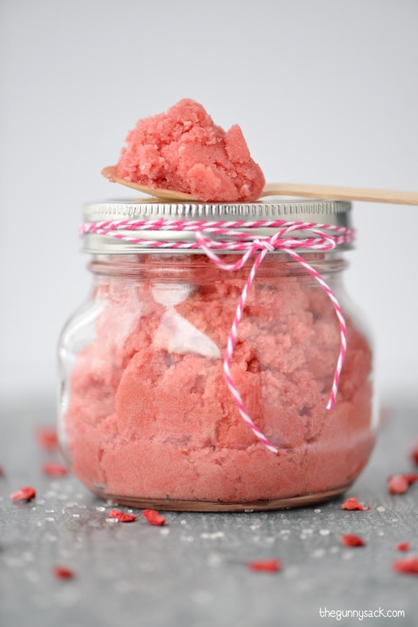 A mason jar filled with a strawberry sugar scrub.
