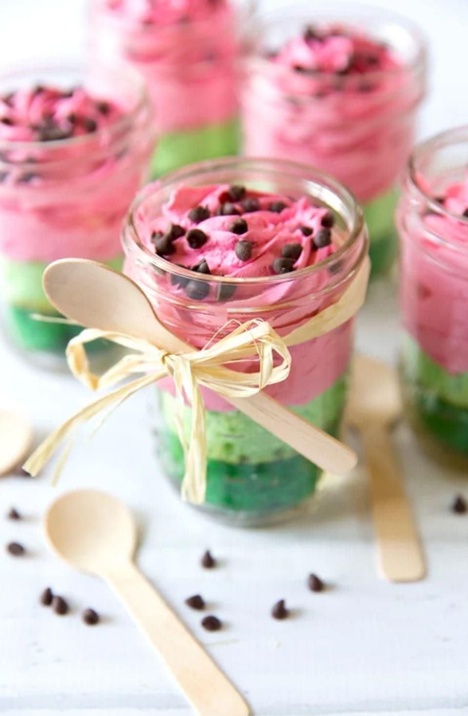 Layered green and pink cake slices in mason jars.
