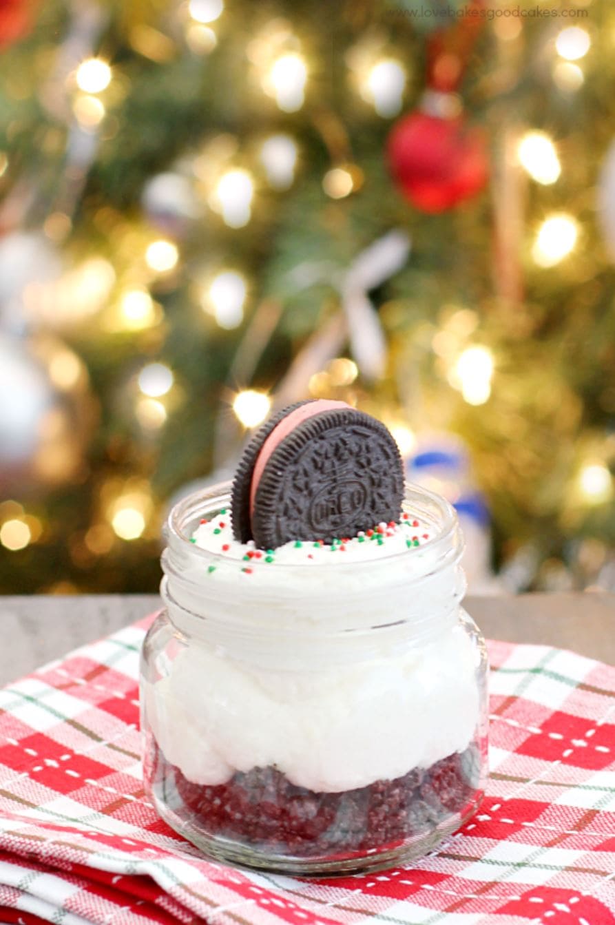 A mason jar filled with a white chocolate Oreo cheesecake and topped with an Oreo cookie.