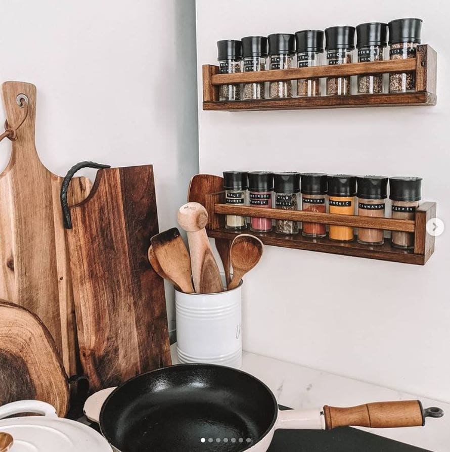 IKEA spice racks stained dark and holding spices near a stove.